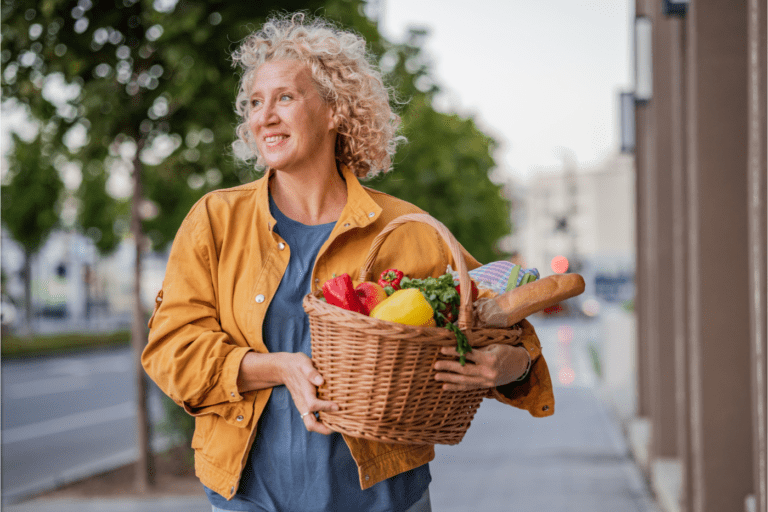 featured image for 101+ Proven Tips To Live a Sustainable Life in 2024 showing a woman with a basket full of fresh produce