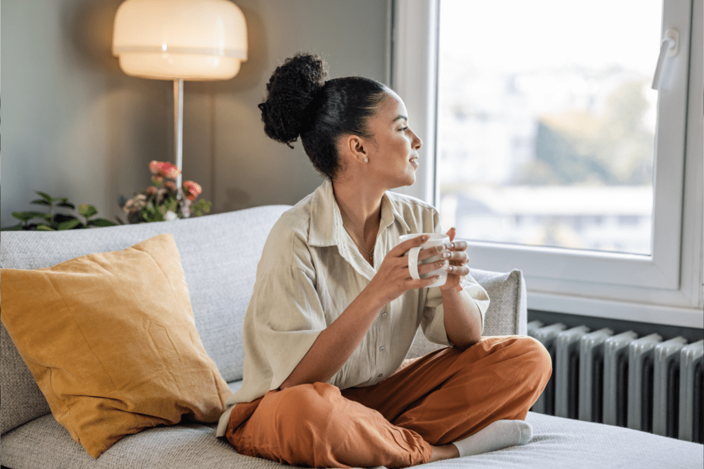 featured image in Why You Absolutely NEED A Morning Routine ASAP showing a woman enjoying her morning with a coffee in her hands