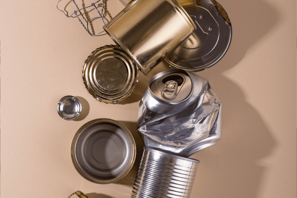 featured image for a blog post called Sustainable Cookware: 7 Reasons Why You Definitely Need It, showing trashed conserve cans