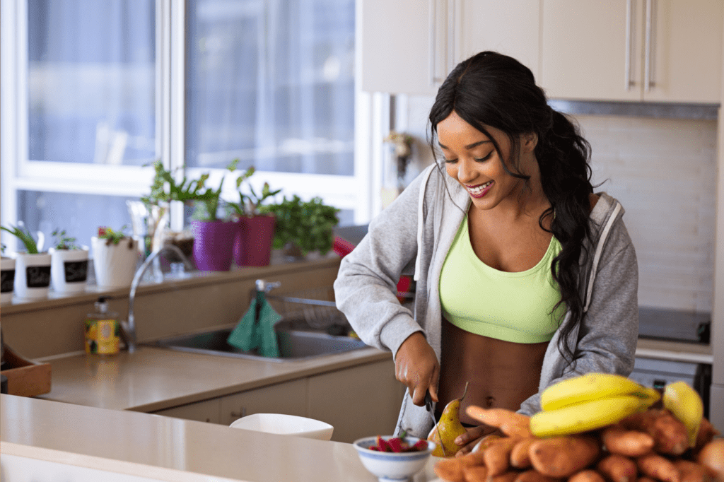 featured image in Why You Absolutely NEED A Morning Routine ASAP showing a fit woman making healthy food