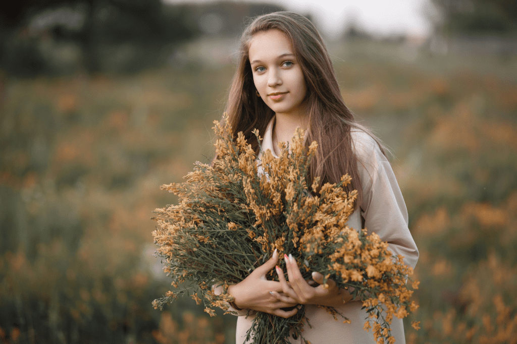 image for 7 Best Intention-Setting Prompts To Kickstart Your Day with Purpose, showing a young woman holding a bouquet of flowers