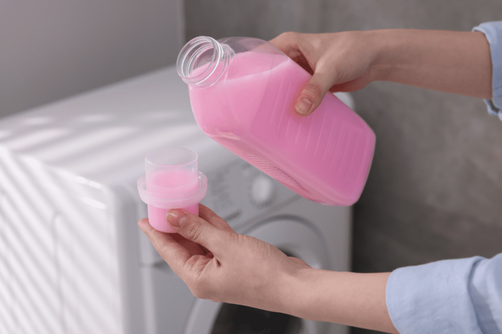 image showing a woman pouring laundry detergent