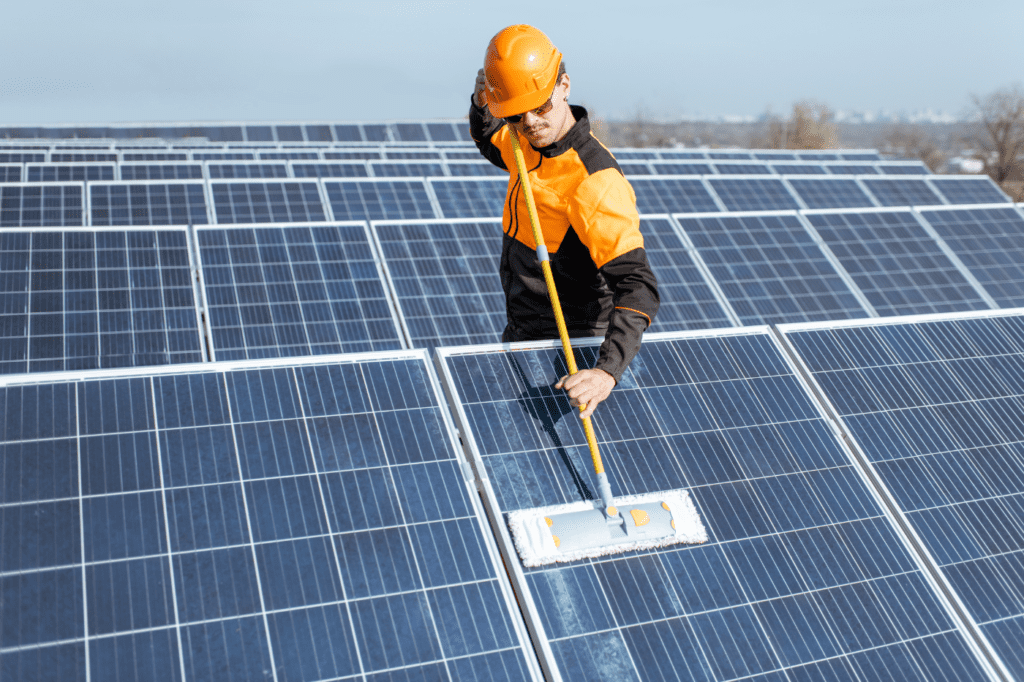 image showing a man cleaning solar panels