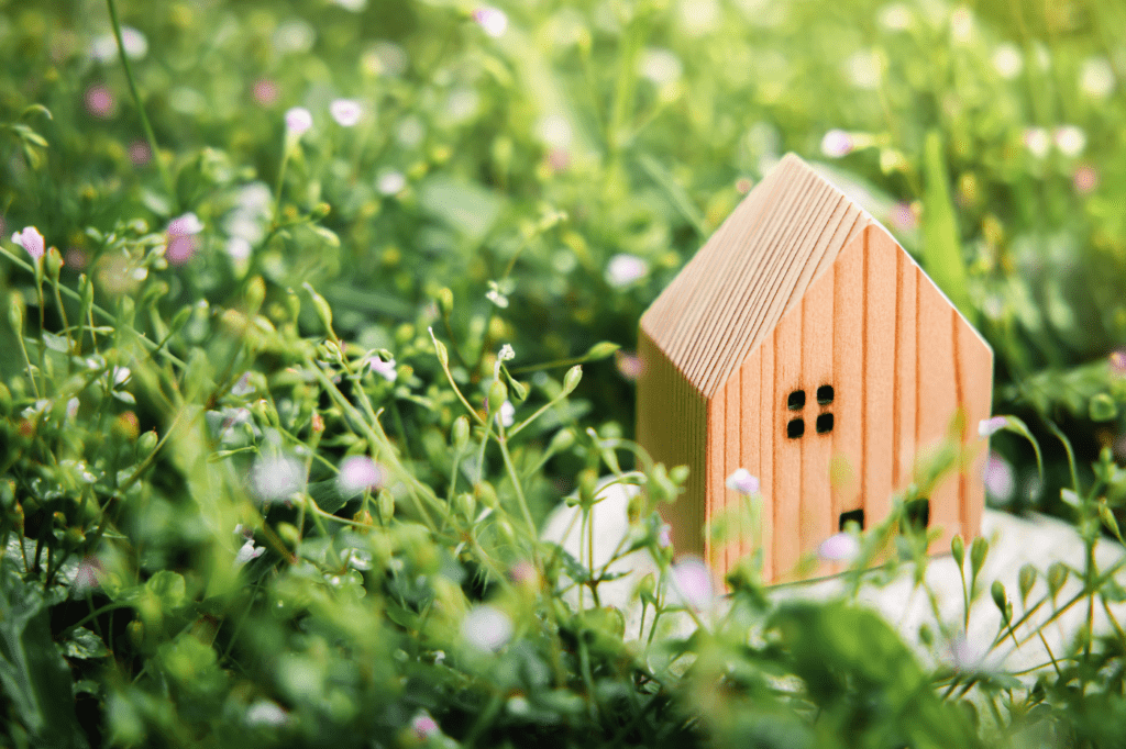 image showing a wooden house sitting in grass
