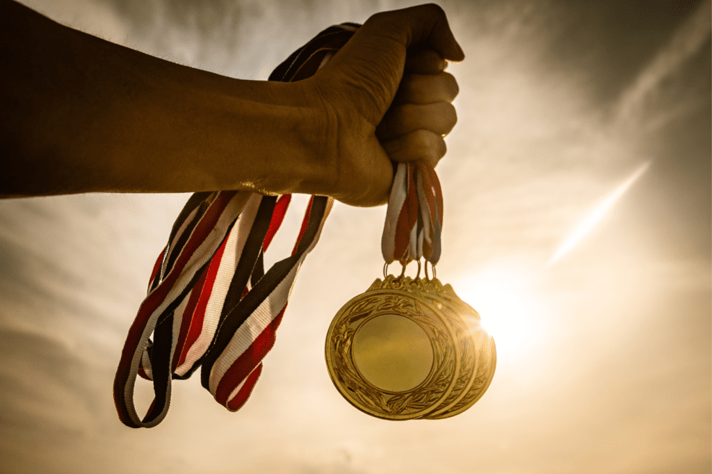 a man holding gold medals